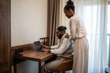 Obraz premium Couple working on laptop in hotel room exploring digital nomad lifestyle