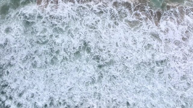 Ocean water flowing forward. Sea surf washing the beach. Ocean waves forming patterns. Sea movement along coastline. Ocean waves rolling steadily. Sea water shifting in motion.