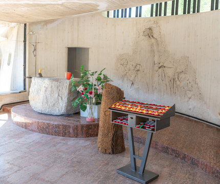 Vajont Dam Memorial Chapel interior: Stone altar and votive candles dedicated to the 1963 tragedy victims, Italy