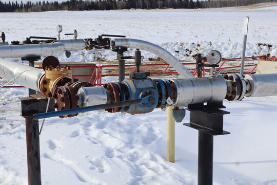 This shows an industrial insulated pipeline system, used for oil or natural gas transmission in a cold climate. This specific setup includes a series of pressure or steam gauges used to monitor psi.