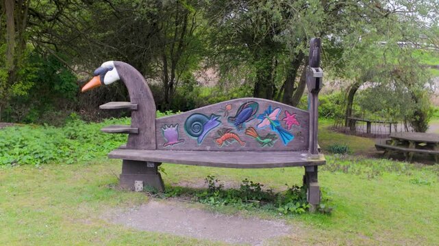 Whimsical carved bird-shaped bench in a park