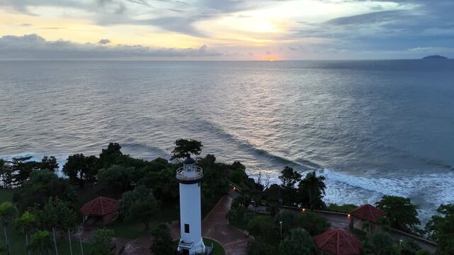 Aerial static shot of Rincon lighthouse at sunset overlooking ocean coastline