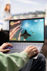 Excited gamer playing online competition game in airport terminal, strategy and interactive action while waiting plane. Modern travel moment with gaming as relaxation and entertainment. © DC Studio