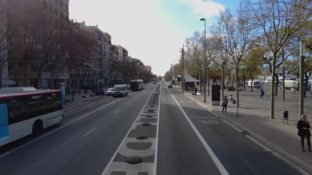 Street view around the downtown of the capitol city Barcelona, riding on the roof of a bus on a sunny spring day.