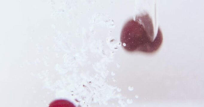 Ripe cherries splash into water, surrounded by air bubbles, Fresh, nutritious and ready for washing before eating