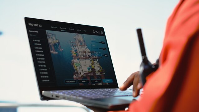 Close up of laptop used by drilling rig worker to monitor infrastructure systems. Offshore installation manager calibrating equipment with notebook device software