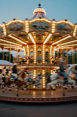 Obraz premium The carousel spins in the amusement park as the evening light shines. Riders enjoy their time on colorful horses and other animals, creating a fun atmosphere for all Generative AI