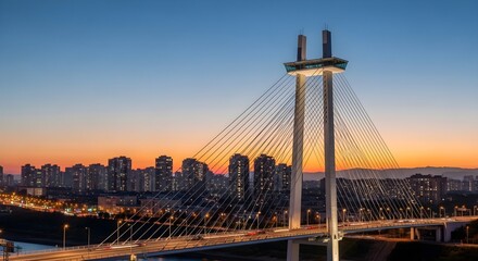 Fototapeta premium cable-stayed bridge at sunset with city skyline
