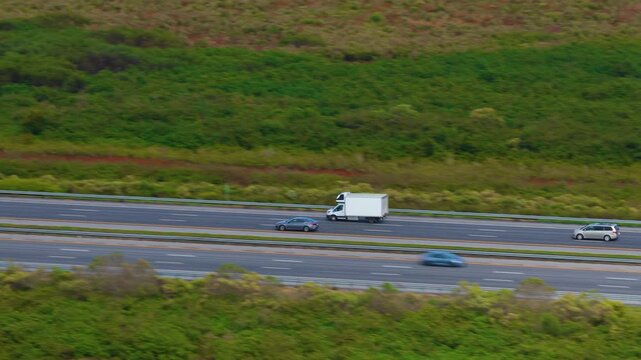 Cargo box truck driving on American interstate freeway hauling goods.