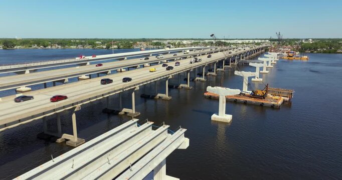 Highway bridge construction in Ellenton, Florida. Development of Trooper J.D. Young Memorial Bridge crossing the Manatee River. American freeway road with moving traffic cars.