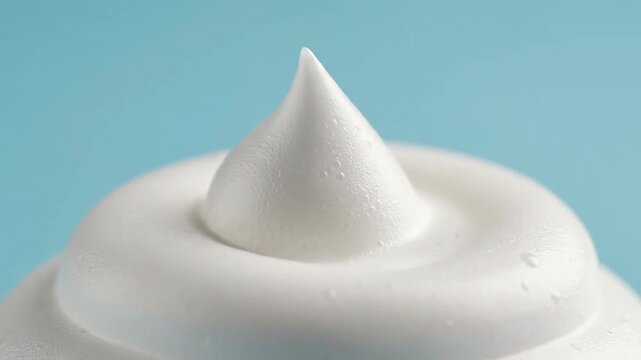 A close-up shot of a swirl of white, fluffy and creamy substance on a blue surface