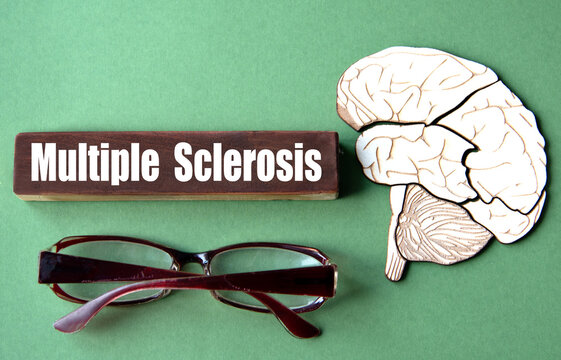 The word MULTIPLE SCLEROSIS is written on wooden cubes against a green background with an image of a skull and brain.