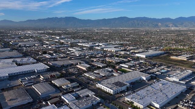 Wide aerial view of industrial warehouse district and city sprawl