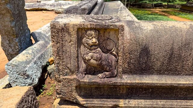 Ancient Muragala (guard stone) with a finely carved lion in a historic Sri Lankan temple setting, reflecting royal symbolism and architectural craftsmanship from the Anuradhapura and Polonnaruwa eras.