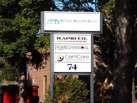 Nepean, Ontario, Canada &ndash; July 27, 2025: A white pylon sign at 74 Auriga Drive lists businesses including "Ottawa Builder Sales, Rapid CO2, PSL Mechanical, and CertiCare."