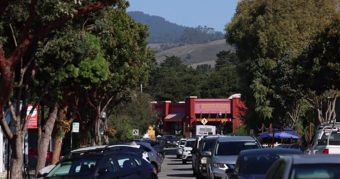 Half Moon Bay, California, USA - October 31, 2025: Afternoon traffic passes through the cityscape of historic downtown.