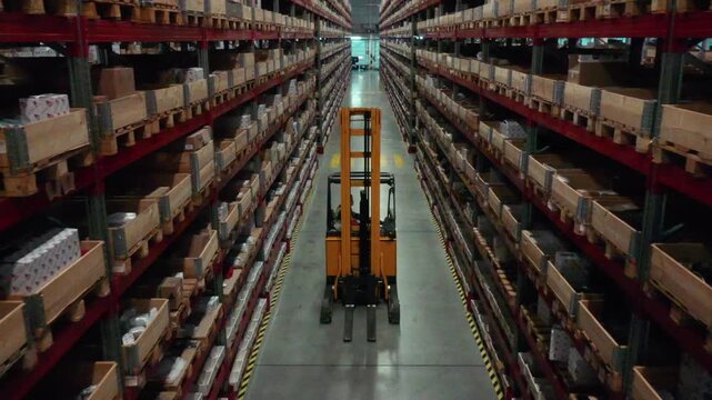 Drone following forklift through warehouse storage aisle