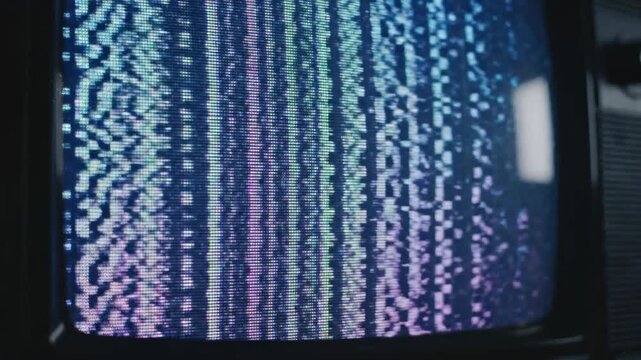 This captures a television screen experiencing technical difficulties, displaying a distorted green and blue error screen with static and noise, indicating a problem with the broadcast or signal.