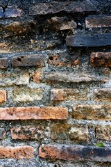 Naklejka premium The old house walls that are damaged and moldy with exposed bricks