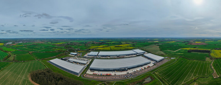 Aerial view of Appleby Magna Industrial Park featuring large modern warehouses surrounded by green countryside and yellow fields in Appleby Magna, England, United Kingdom.
