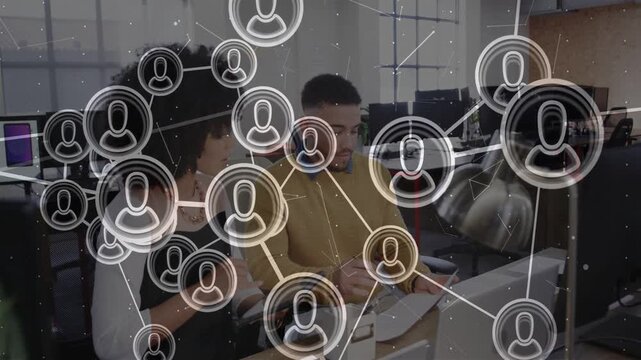 Woman tapping tablet and man typing at desk, activating network overlay visualizing team data