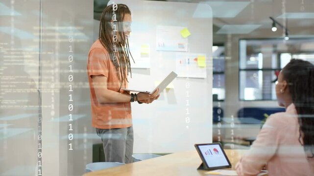 Lead opening laptop causing brief binary overlay pointing to notes and tablet charts for business