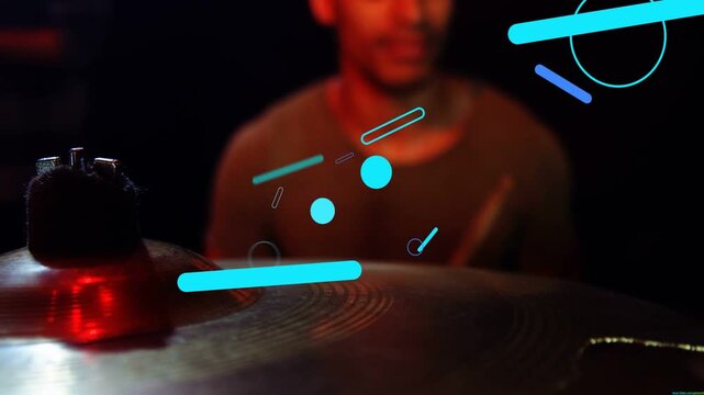 Male drummer raising stick and striking kit starting turquoise graphics forming on cymbal for music