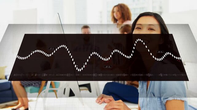 Woman at desk typing while system starting overlay and rising waveform, obscuring team for business