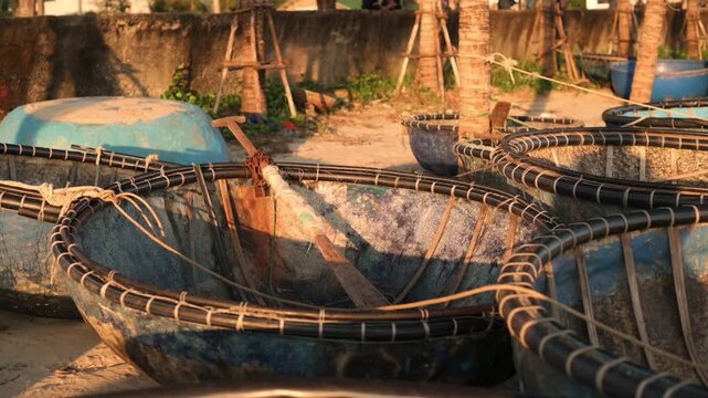 Rustic Coastal Scene. Vintage Boats Resting Along Seaside With Warm Sunset Ambiance. Weathered Traditional Boats Anchored Near Lush Palm Trees On Vietnamese Coastal Village Beach