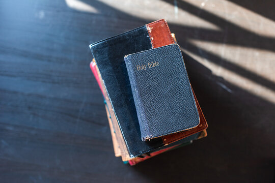 Stacked vintage Bibles on table