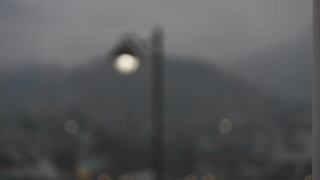 斜面に広がる家並みを背景に雨の公園風景