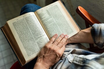 Naklejka premium Person reading vintage book indoors.