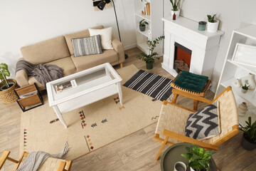 Obraz premium Interior of light living room with green plants, sofa and fireplace, top view