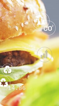 Vertical video: Camera panning right, zooming up, burger sharpening while icons showing eco impact