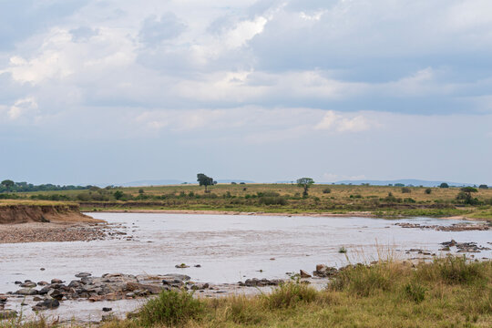 rocky banks along river bend as waters flow through northern serengeti savanna landscape in tanzania