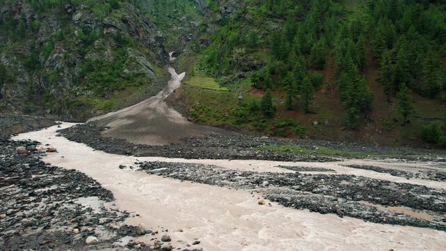 4K shot of Miyar river flowing from glacier in mountains at Miyar Valley, Lahaul, India. Summer in Himalayas. Flowing water of mountain river. Nature landscape.