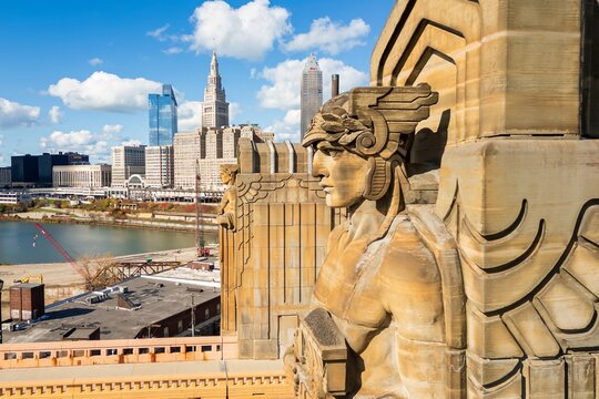 Art deco statue with city skyline and construction in the distance - Cleveland, Ohio