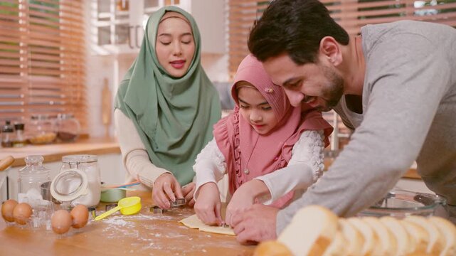 Happy Muslim family baking bakery together in kitchen at cozy home. 