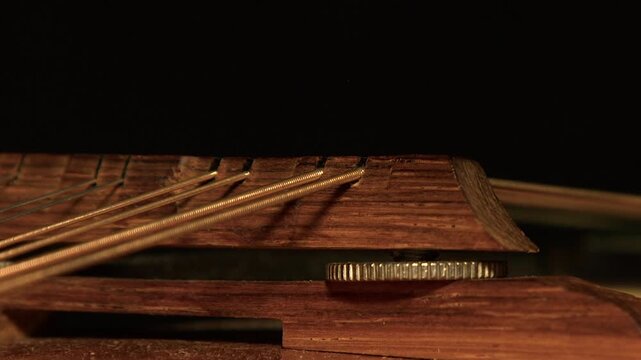 Dark and moody: Light sweeps across strings and bridge of old mandolin