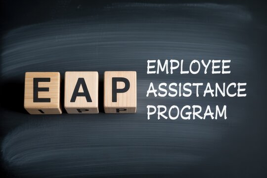 EAP Employee Assistance Program concept with wooden blocks on blackboard background