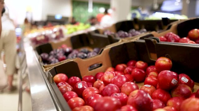 Fresh red apples in display bins at local supermarket grocery store.