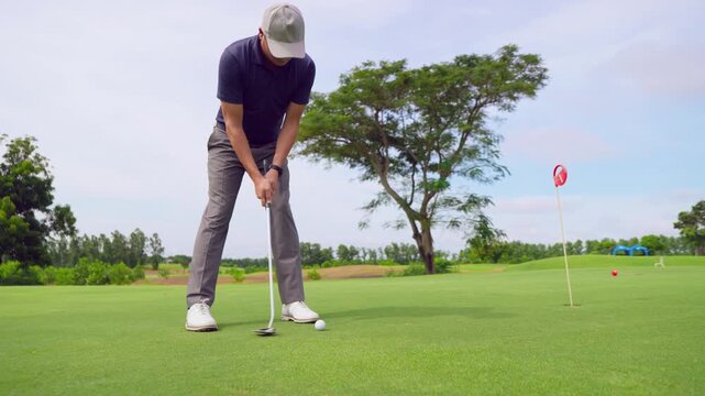 Professional young male golfer swings his club on scenic golf course.
