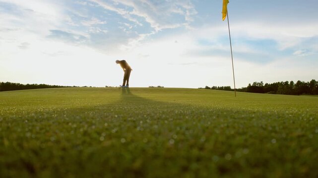 Drone view of professional male golfer playing on scenic golf course. 