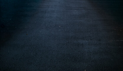 Fototapeta premium Smooth asphalt road surface with subtle texture and dark tones, creating a clean and minimal background ideal for design use, automotive themes, or urban visual compositions.