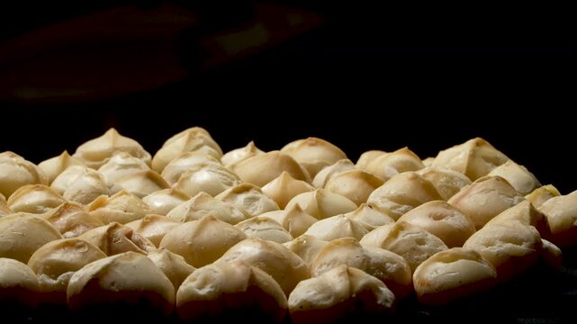 Roasted macadamia kernels with rim light on black background.