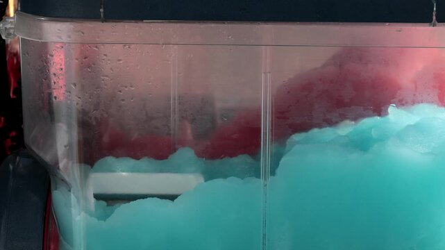 Stockholm, Sweden Red and blue ice slush cooling drink mixing in a drink machine or dispenser. 