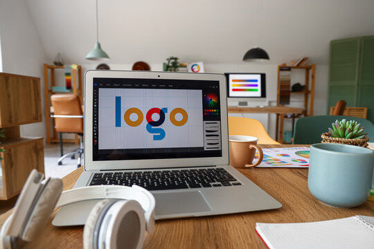 Graphic designer's workplace with laptop in office, closeup