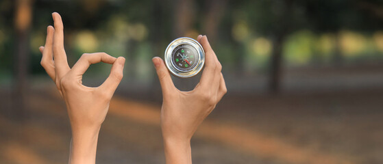 Woman with compass showing OK in forest, closeup © Pixel-Shot