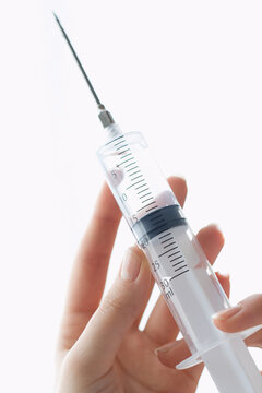 Person preparing an injection with a syringe filled with liquid medication