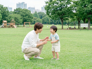 Fototapeta premium 公園の芝生で遊ぶ父親と男の子